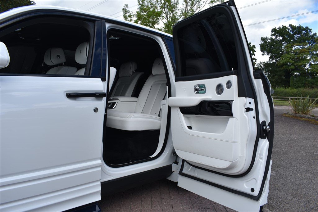 Rolls-Royce Cullinan wedding chauffeur vehicle with rear doors open at luxury wedding venue arrival
