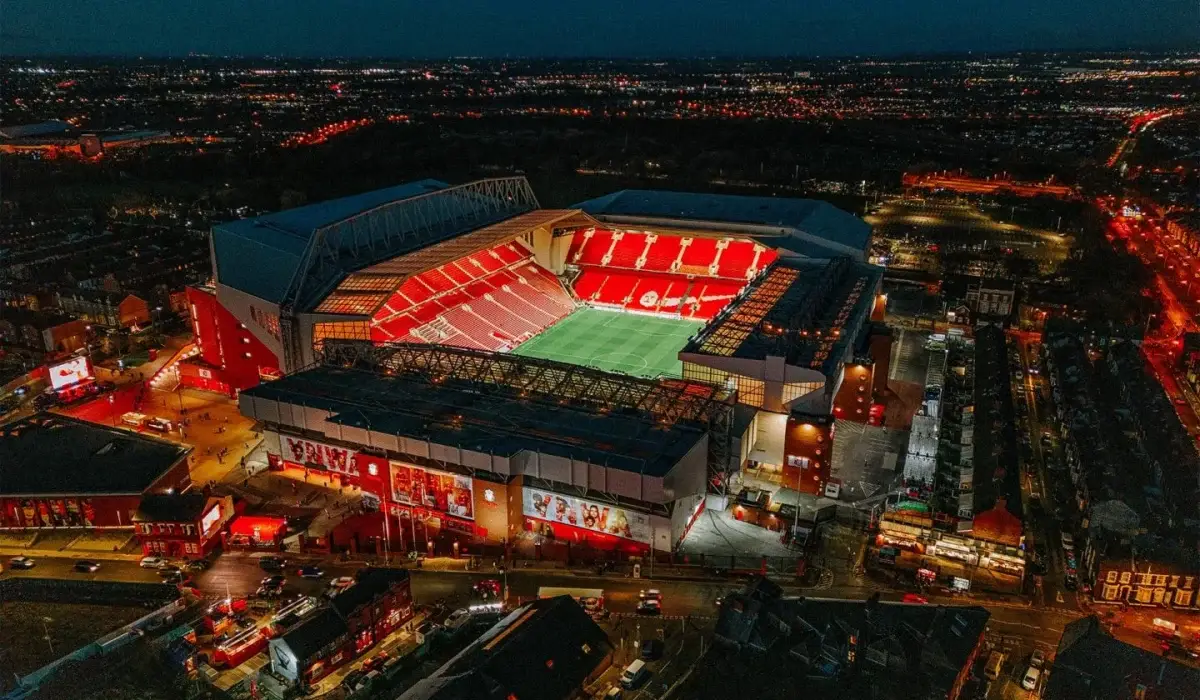 Aerial night view of Anfield Stadium in Liverpool illuminated during an evening match, representing MCR EXEC’s luxury chauffeur services for Liverpool FC fans and VIP guests.