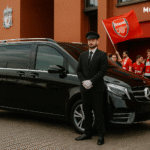 Executive taxi with chauffeur outside Anfield, Arsenal fans waving flag for Liverpool vs Arsenal matchday