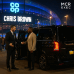 Chauffeur assists client into luxury black Mercedes V-Class outside Co-op Live during Chris Brown concert in Manchester
