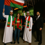 Three Omani football fans stand proudly outside Old Trafford with a luxury Mercedes MPV and MCR EXEC chauffeur.