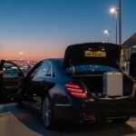 Early Morning Airport Chauffeur Manchester service with a black Mercedes-Benz S-Class operated by MCR-EXEC, showing a professional chauffeur assisting passengers during a pre-dawn airport departure at Manchester Airport.