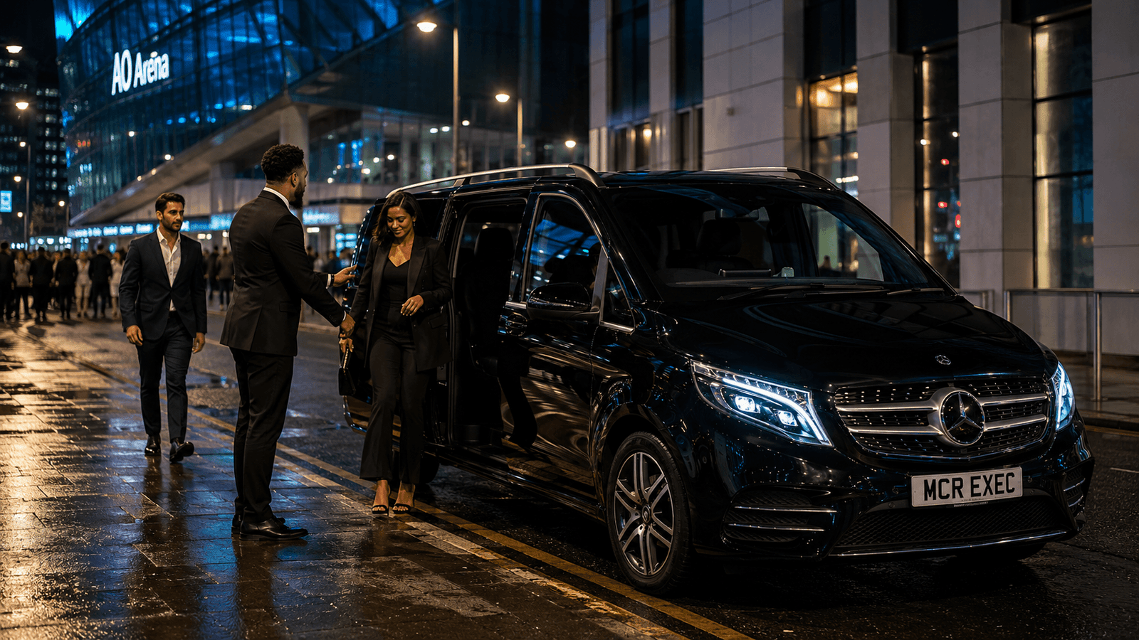 Fury vs Hall AO Arena chauffeur service by MCR EXEC with a black Mercedes V-Class outside AO Arena Manchester on fight night, chauffeur opening the passenger door for VIP guests attending the Tommy Fury vs Eddie Hall event.