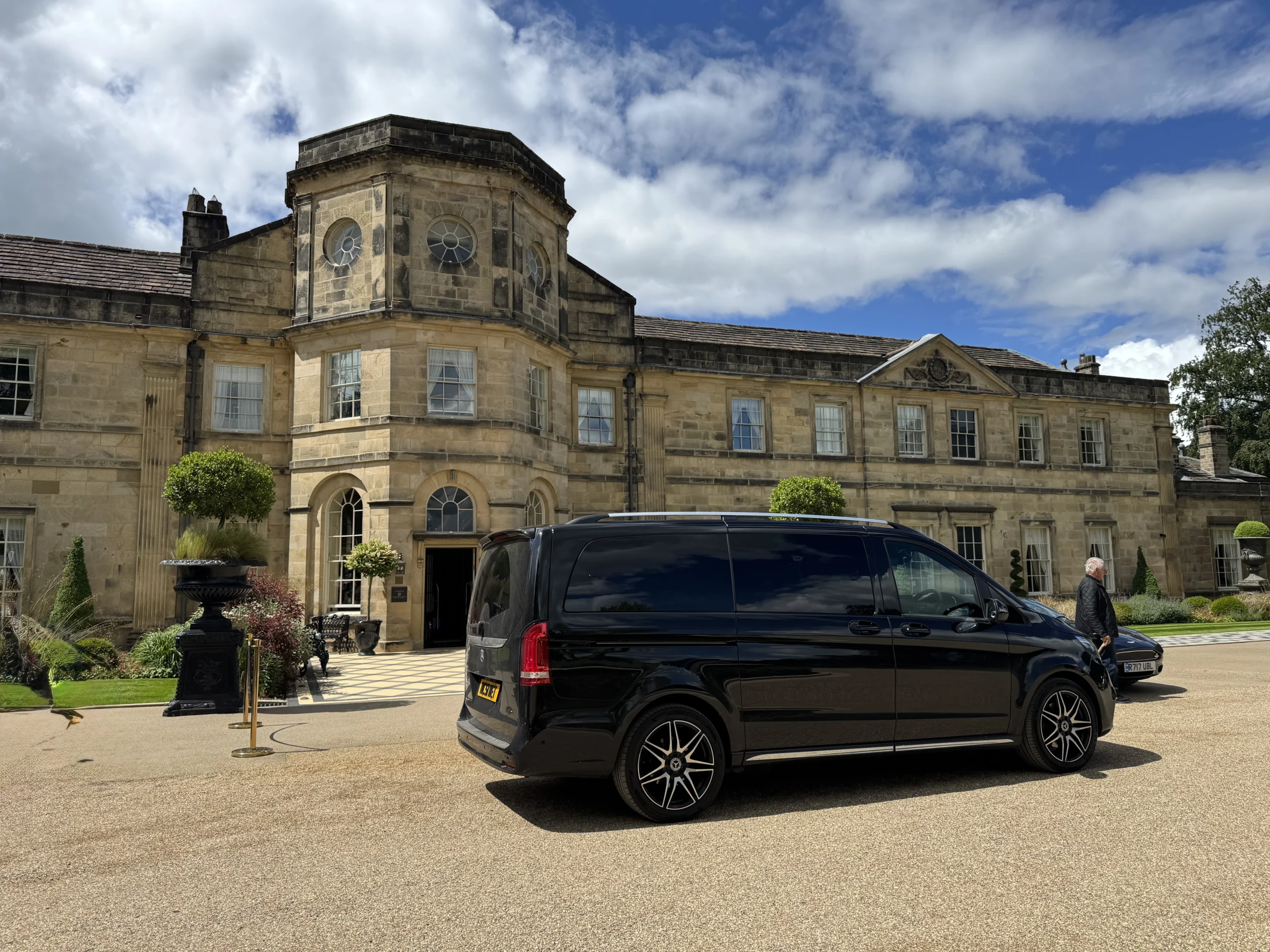 Private UK tours with chauffeur in a Mercedes V-Class outside a historic British country house