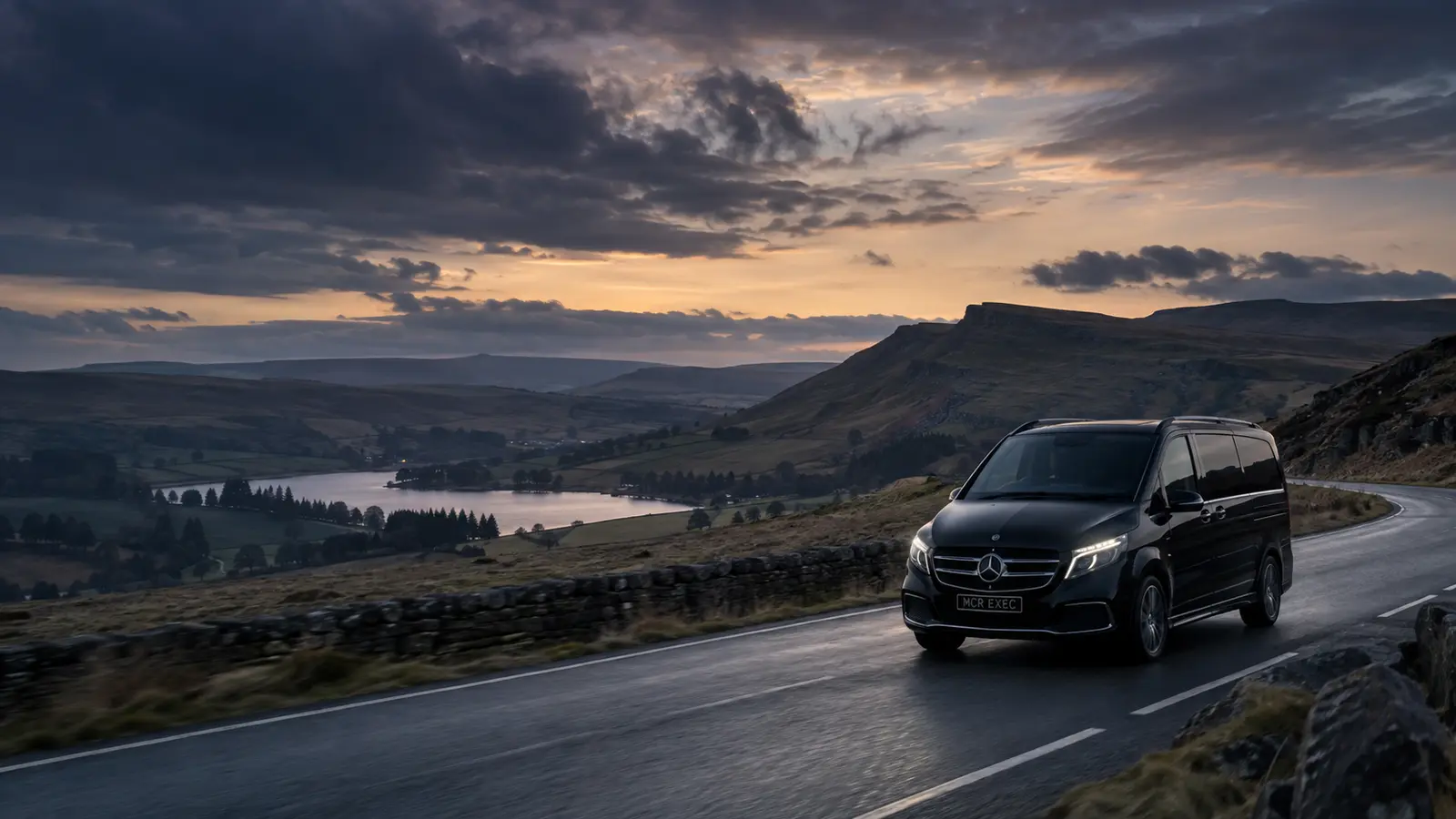 Black MCR EXEC Mercedes travelling through the Peak District at dusk