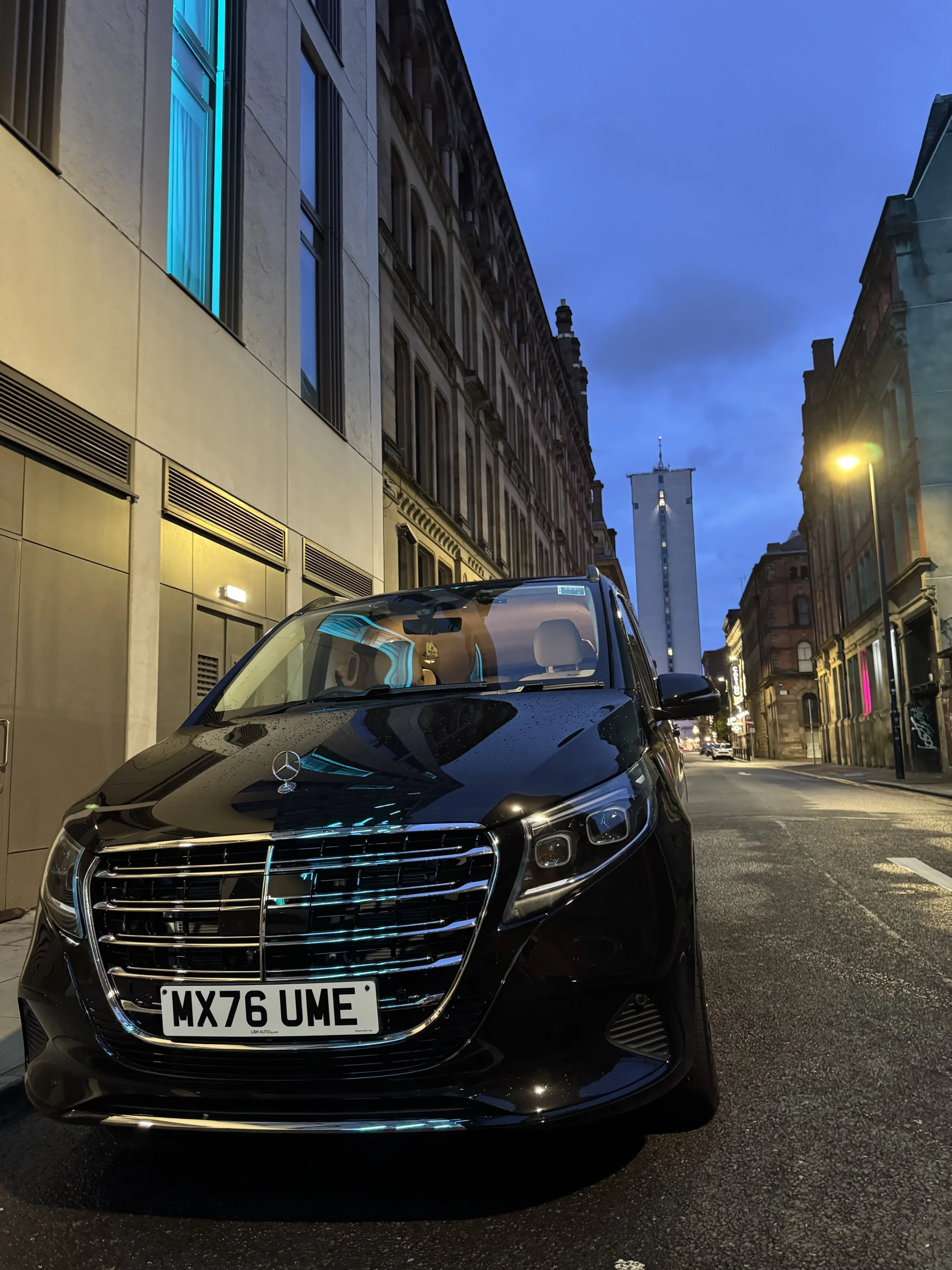 Front view of the black MCR EXEC Mercedes V300 Exclusive on a city street at dusk